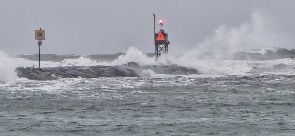 A wave crashes over the Rudee Inlet jetty light during the first nor'easter of the season in Virginia Beach.