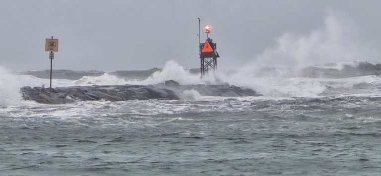 A wave crashes over the Rudee Inlet jetty light during the first nor’easter of the season in Virginia Beach.