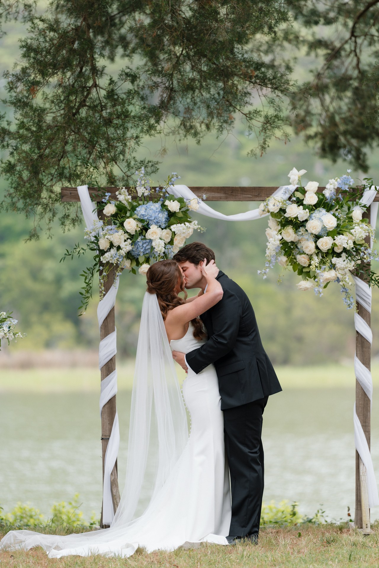Noah and Tara kissing at their wedding on the water