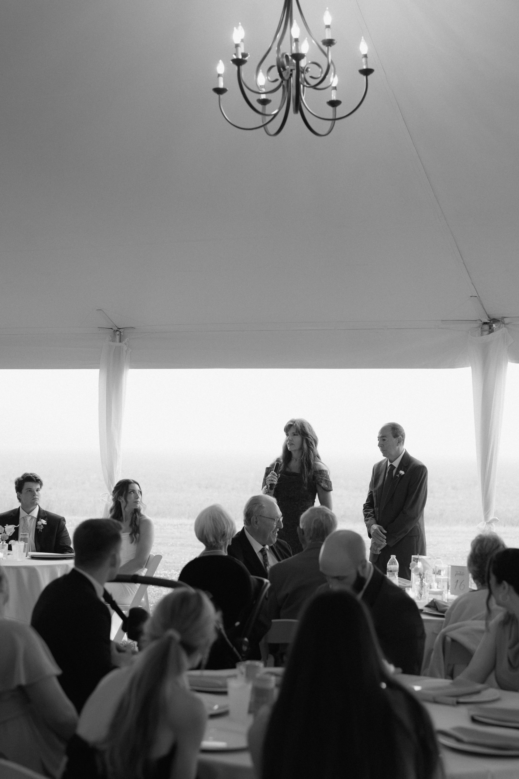 Family and friends gathered under the tent for a wedding toast Family and friends gathered under the tent for a wedding toast